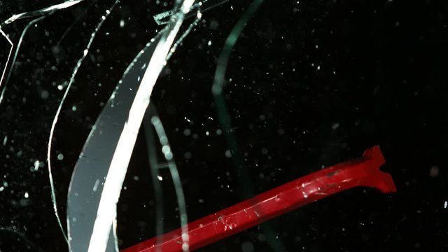 Super slow motion of breaking glass on black background, burglar concept. Filmed on high speed cinema camera, 1000 fps.