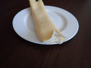   single rolled pancake on a white plate