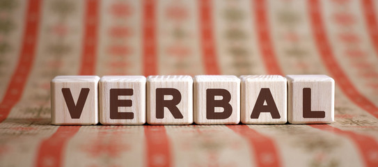 Verbal word on wooden cubes on a color background - obrazy, fototapety, plakaty