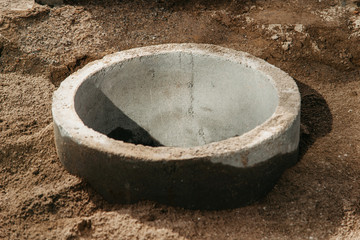 concrete circle for a well and sewerage buried in sand