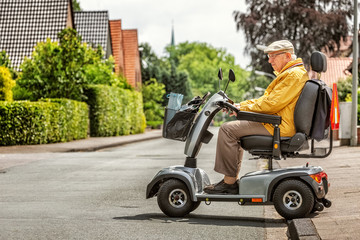 An elderly person drives an electric vehicle - 328358452