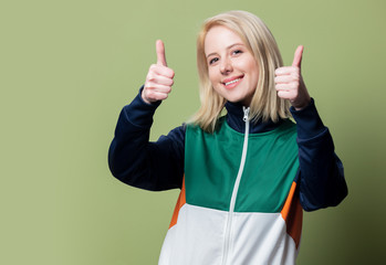 Beautiful blonde woman in 90s sport suit show OK gesture