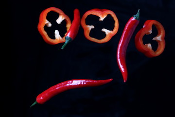 red juicy peppers in the air on a dark background