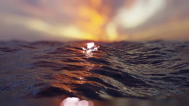 Ocean waves in the evening at sunset with bright. Too many shiny reflections of the sun in the water with bokeh. 4K loop animation.