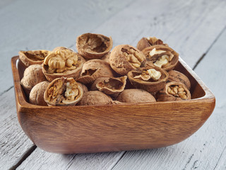 Walnut kernels on a dark table with a colored background