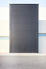 big black metal door in a modern white building