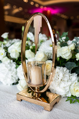 Table at a luxury wedding reception. Beautiful flowers on the table. Serving dishes, glass glasses, waiters work.