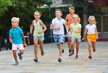 Fototapeta na wymiar Group of children running outdoors in city street