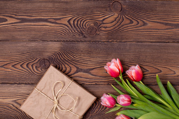 Gift box and tulip flowers on rustic table for March 8, International Womens day, Birthday or Mothers day, beautiful spring card.
