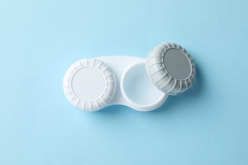 Case for contact lenses on blue background, top view