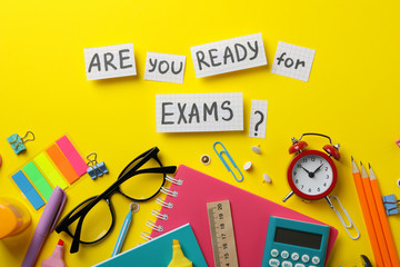 Inscription Are you ready for exams? and stationary on yellow background, top view