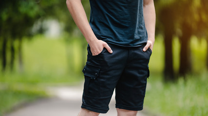 Man in black shorts and blue t-shirt outdor.