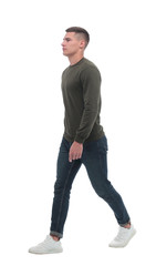 in full growth. a confident man in jeans walks forward .