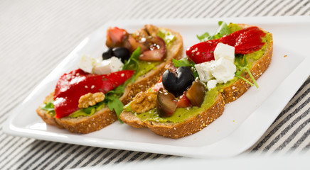 Fototapeta na wymiar Sandwich with vegetables, walnut and feta cheese at plate