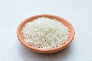 Natural raw white rice grains, on display in bowl