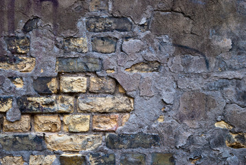 old grey-yellow brick wall and plaster