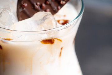 Creamy cocktail with ice and slice of chocolate. Selective focus. Shallow depth of field.