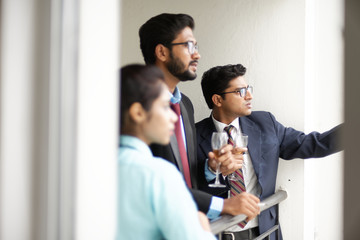 Corporate meetings between  young and energetic Indian Bengali bosses/officers/managers and secretary at balcony of the office building regarding buying a project land. Indian corporate lifestyle