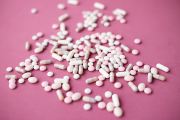 Bunch of antiviral and analgesic pills and tables on bright pink background. Painkillers for the head, abdomen, and back. Treatment of dangerous infection with the Chinese coronavirus covid-2019