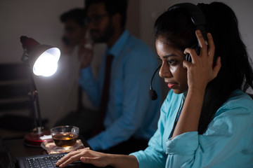 Indian Bengali attractive brunette young woman in office wear enjoying success while sitting on an office table  in a corporate office/bpo/call center. Indian corporate lifestyle.