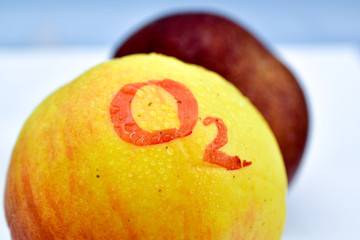 text O2 handwritten on a yellow apple