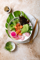 Hawaiian salmon poke bowl with seaweed, avocado, watermelon radish and cucumber. Top view, overhead, flat lay