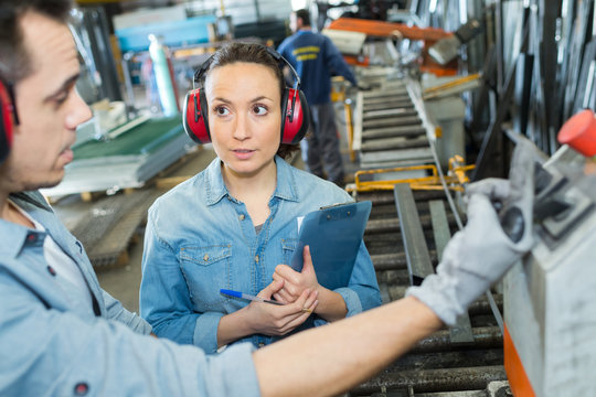 happy male and female carpenters with digital tablet in workshop