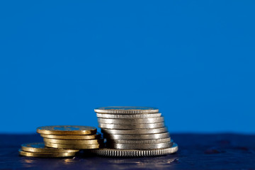 Small piles of a few Swiss coins on blue background