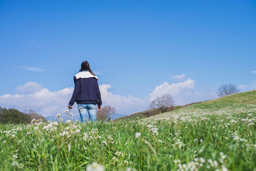 Fototapeta premium Rear view of hispanic brunette woman in casual wear walking on field