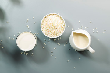 Rice milk with rice grains on gray table. Copy space, top view