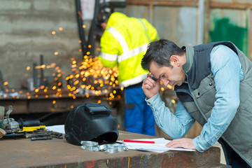 welder looking at a paper