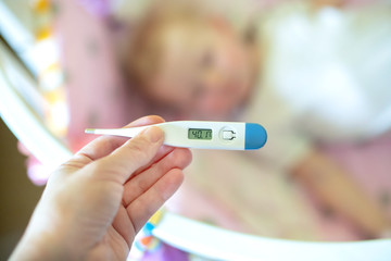 Close-up medical thermometer, Parent measuring temperature of ill kid, 1 years old toddler girl...