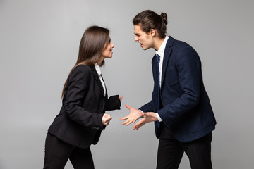 Portrait of displeased angry quarrel business colleagues couple isolated over white wall background.