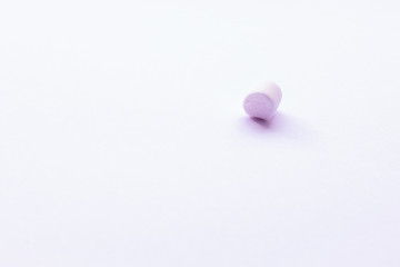 Single Marshmallow isolated on white background. Minimal sweet photo of small pink treat. A lot of text space, room for copy.