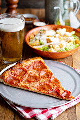 Pepperoni pizza slice with a side salad