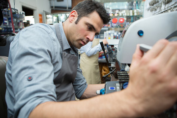 man making keys in a machine