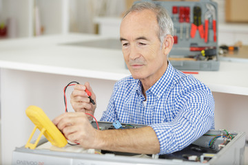 senior electrician working at home