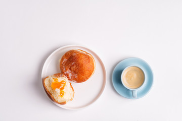Homemade baked donut on a white ceramic plate and cup of coffee on a light grey background. Flat lay.