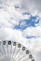 Ferris wheel on background of cloudy sky