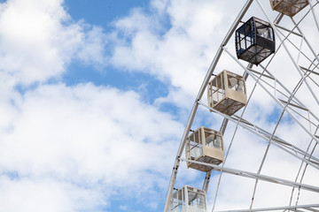 Ferris wheel on background of cloudy sky