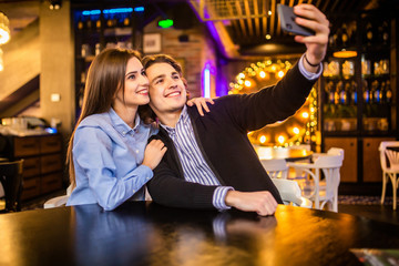 Young happy couple in the cafe taking selfie in cafe