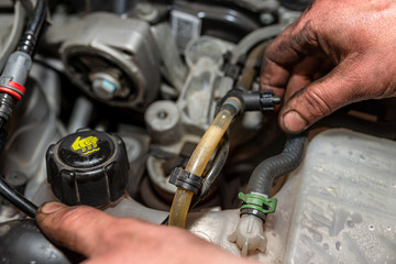 The mechanic bleeds the fuel system with a pump that is on the fuel line, after installing a new...