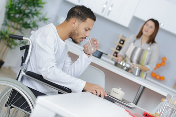 man on wheelchair drinking water