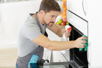 man cleaning oven at home