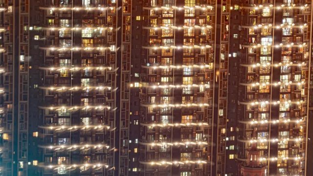 Timelapse of bright apartment building day to night.Time lapse of modern lifestyle in Chinese city with crowded dense residential buildings. Night to morning transition overnight of rows of flats.