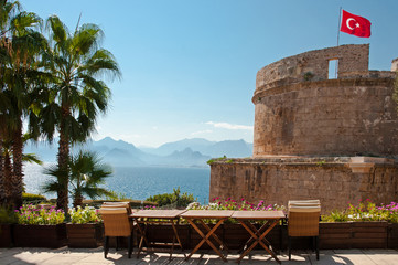 Obraz premium Flag of Turkey above the Hidirlik Tower, Karaalioglu Park in the historic town Kaleici, Antalya, Turkey