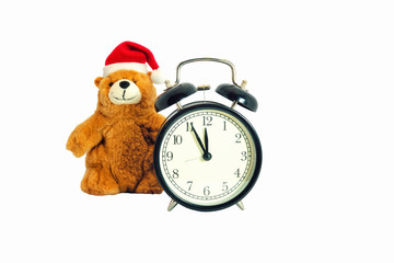 Children's toy teddy bear in Santa Claus headdress and analog clock. Isolate on a white background.