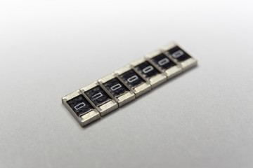 Abstract close-up of arranged 1206 SMT chip resistors power electronics components isolated on white background