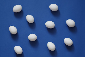 Pattern with white eggs on blue background. Top View. Copy Space. Pop art design, creative food concept. Banner. Eggs in minimal flat lay style
