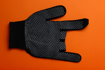Black work gloves rock and roll gesture, on orange background